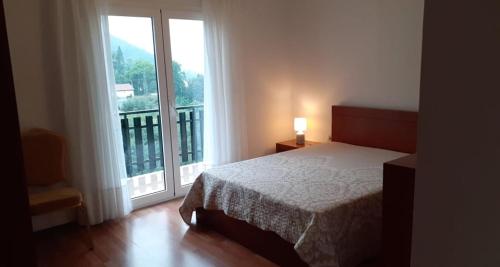 a bedroom with a bed and a large window at Casa Marciana in Geres