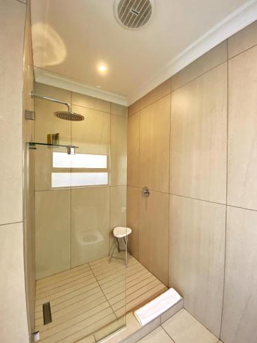 a bathroom with a shower with a glass door at The Northcliff Boutique Hotel in Johannesburg
