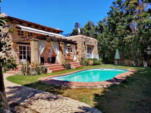 a house with a swimming pool in the yard at Rock House's Villa Melody in Plataniás