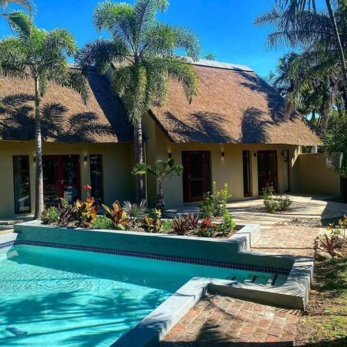 a house with a swimming pool in front of a house at La Lechere Guest House in Phalaborwa