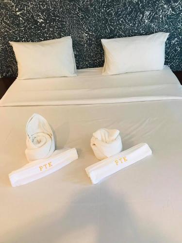 a white bed with two slippers on it at PTK BEACH in Chaweng