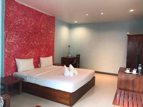 a bedroom with a bed with a red wall at PTK BEACH in Chaweng