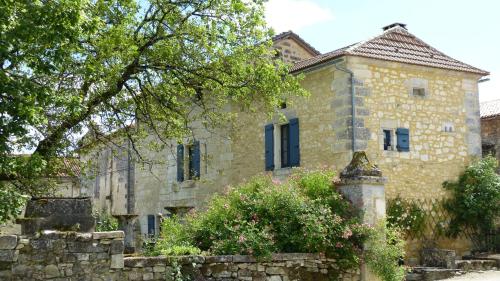 an old stone house with a stone wall and trees at L'Echappée Belle Périgord in Cercles
