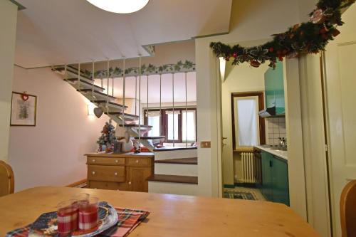 a kitchen with a table and a spiral staircase at Villa al Campo in Madonna di Campiglio