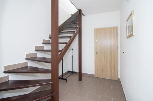 a wooden staircase in a room with a door at Penzion Anareta in Frýdek-Místek