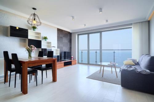 a living room with a table and a couch at Apartamenty Na Klifie in Ustronie Morskie