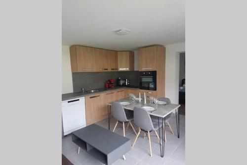 a kitchen with a table and chairs in a kitchen at maisonnette entre lac de Passy et montagnes in Domancy