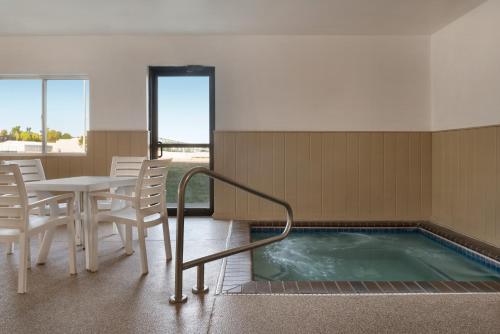 a hot tub in a room with a table and chairs at Super 8 by Wyndham Sioux Falls in Sioux Falls