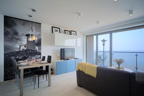 a living room with a couch and a table with a lighthouse on the wall at Apartamenty Na Klifie in Ustronie Morskie