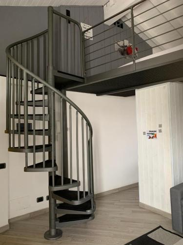 Una escalera de caracol metálica en una habitación con techo en APPARTAMENTO PIERANGELO DI FRONTE MALPENSA T1 e T2 en Vizzola Ticino