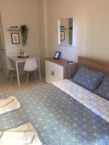 a bedroom with two beds and a desk and a table at Nikoletta's Studio 2 in Komotini