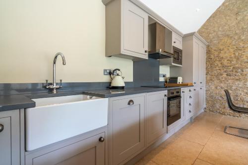 a kitchen with white cabinets and a sink at Bull Pen in Dyrham