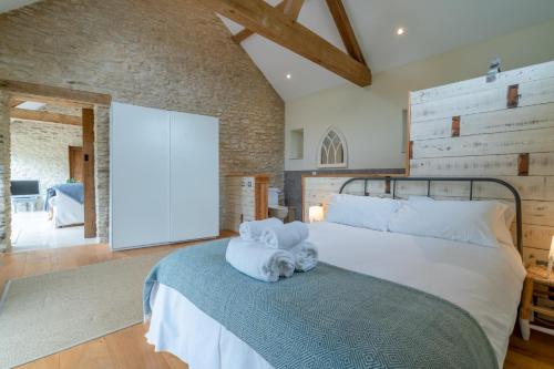 sypialnia z dużym łóżkiem z ręcznikami w obiekcie Bull Pen w mieście Dyrham