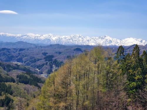 a view of a mountain with snow covered mountains at プチホテル葡萄屋 in Hakuba