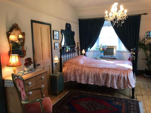 um quarto com uma cama, uma cómoda e uma janela em Pretty Victorian Garden Flat em Radipole