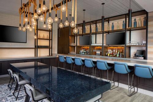 a bar with a black table and blue chairs at Hyatt Regency Boston Harbor in Boston