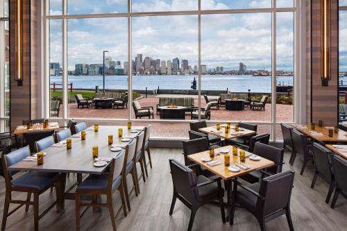 a restaurant with tables and chairs and a large window at Hyatt Regency Boston Harbor in Boston