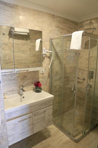 a bathroom with a sink and a shower at Burçman Hotel Vişne in Yıldırım