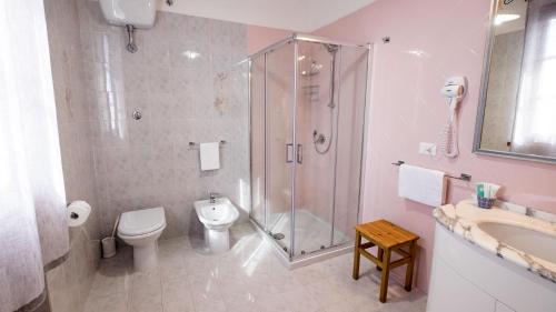 a bathroom with a shower and a toilet and a sink at Villa Mandrioli in Cecina