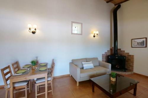 a living room with a dining table and a fireplace at Son Fornes in Algaida