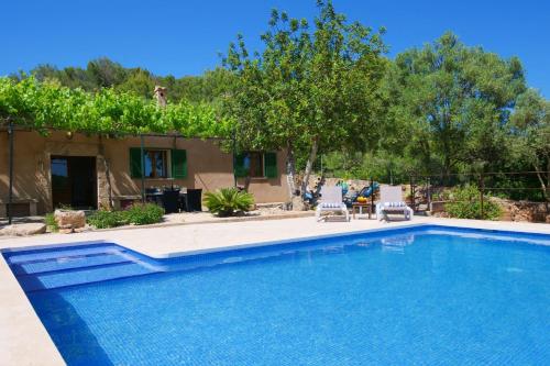 a swimming pool with two chairs and a house at Son Fornes in Algaida