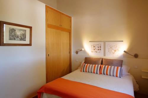 a small bedroom with a bed and a wooden door at Son Fornes in Algaida