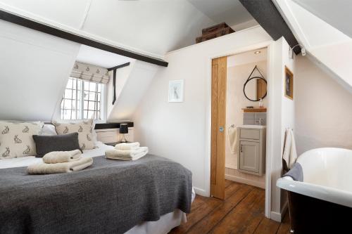 ein Schlafzimmer mit einem großen Bett und einem Waschbecken in der Unterkunft Millers Cottage in Chipping Campden