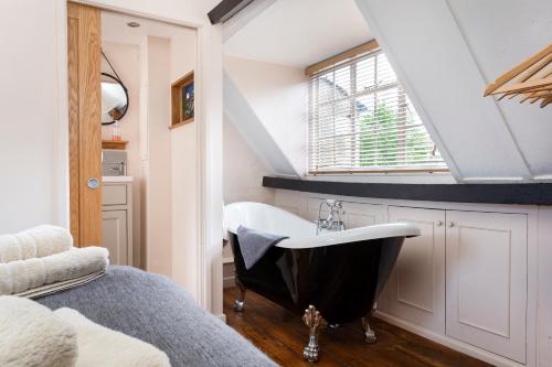 ein Bad mit einer schwarzen und weißen Badewanne im Dachgeschoss in der Unterkunft Millers Cottage in Chipping Campden