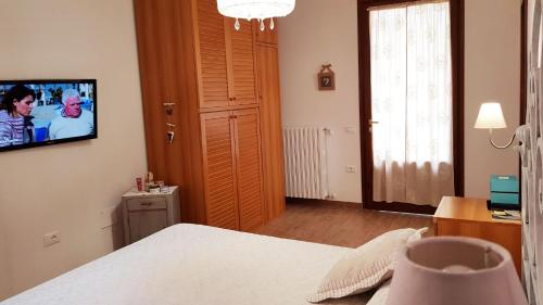 a bedroom with a bed and a television on a wall at Villa Mandrioli in Cecina