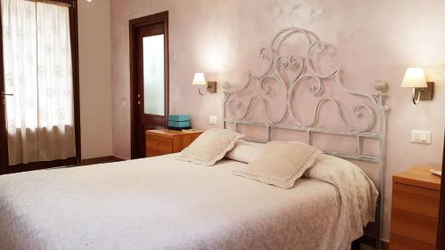 a bedroom with a large white bed with two pillows at Villa Mandrioli in Cecina