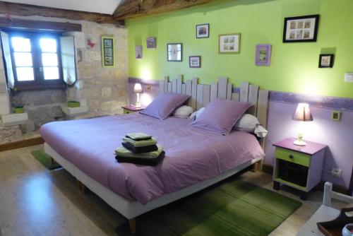 sypialnia z łóżkiem z fioletową pościelą i zielonymi ścianami w obiekcie L'Echappée Belle Périgord w mieście Cercles