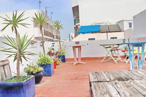 un patio con macetas y mesas en un edificio en Habitación Cañaveral Playa Conil IV, en Conil de la Frontera