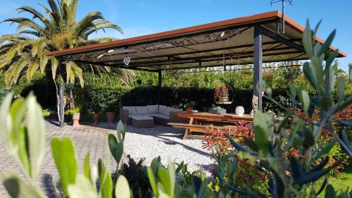 a pavilion with a picnic table in a garden at Villa Mandrioli in Cecina