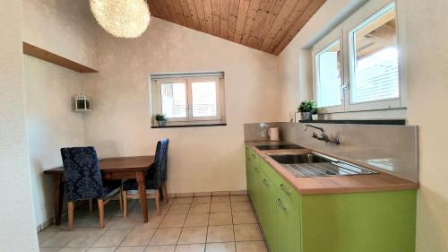 a kitchen with a sink and a table with chairs at privates Ferienhaus Lungern see-you in Lungern
