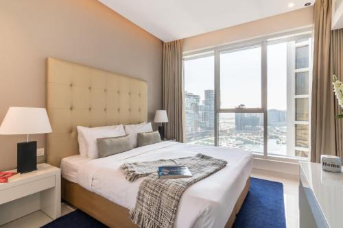 a bedroom with a large bed with a large window at The Smart Concierge - The Vogue in Dubai
