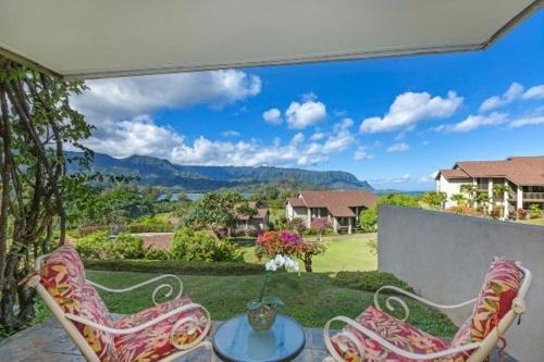 a patio with two chairs and a table with a view at Hanalei Bay Resort 6101 condo in Princeville