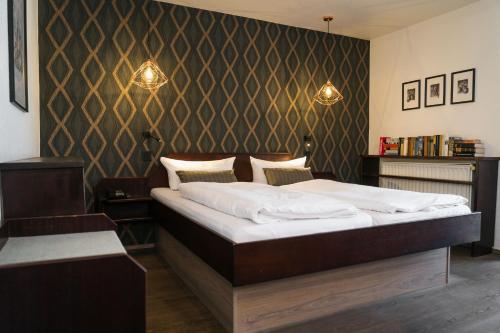 a bedroom with a large bed and a wall at Hotel Stümpelstal in Marburg an der Lahn