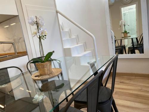 una escalera de cristal con una mesa de cristal con una planta en Fuencarral Apartments, en Madrid