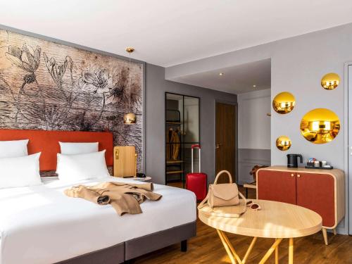 a hotel room with a bed and a table at Mercure Saint Omer Centre Gare in Saint-Omer