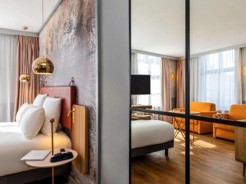 a hotel room with a bed and a desk at Mercure Saint Omer Centre Gare in Saint-Omer