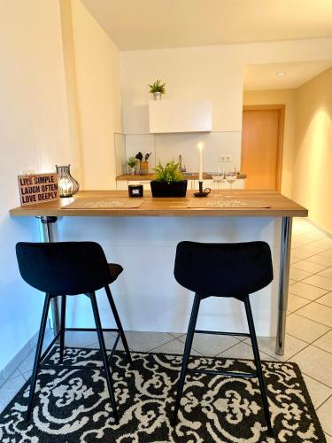 a kitchen with two chairs sitting at a counter at Private Spa mit Sauna und Whirlpool in Schrozberg