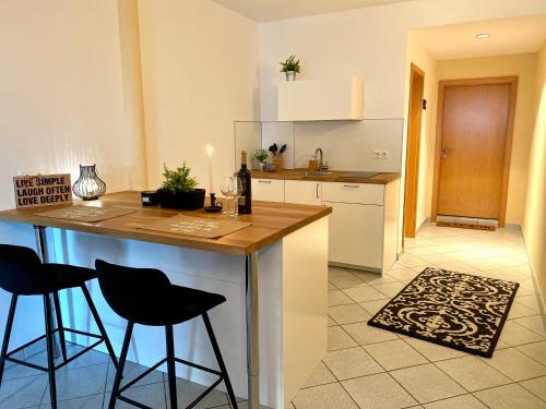 a kitchen with a counter and two bar stools at Private Spa mit Sauna und Whirlpool in Schrozberg