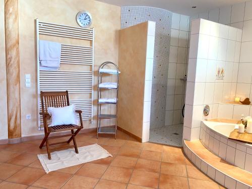 a bathroom with a chair and a tub at Private Spa mit Sauna und Whirlpool in Schrozberg