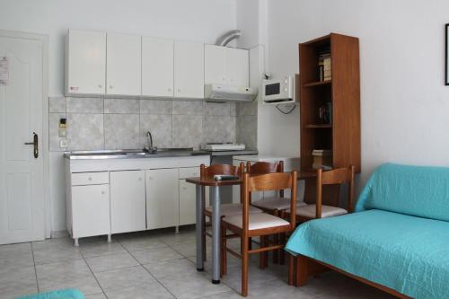 a small kitchen with a table and a couch at Lena Studios in in Hanioti
