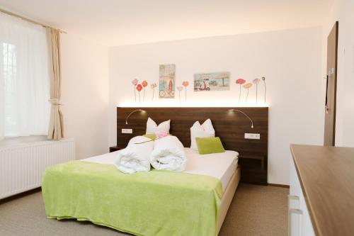 a bedroom with a large bed with green sheets and pillows at Velden24 - create your own stay in Velden am Wörthersee