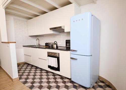 una nevera blanca en una cocina con suelo a cuadros en Scalo al Castello, en Locate di Triulzi