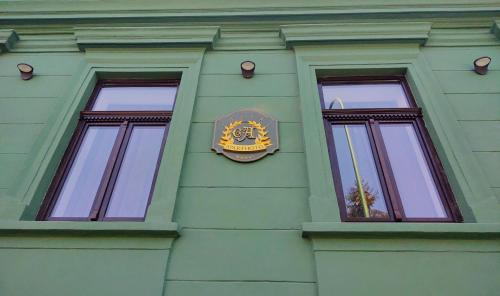 a clock on the side of a building with two windows at CezAri ApartHotel in Braşov