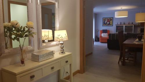 科巴羅的住宿－Varosha Combarro，客厅配有带鲜花和镜子的桌子