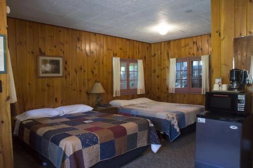 a bedroom with two beds and a television in it at Riverside Point Resort in Park Rapids
