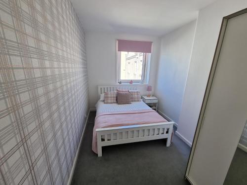 a small bedroom with a bed and a mirror at Bespoke Tours Scotland Accommodation @ Morrison Street in Edinburgh